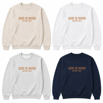 Four crewneck sweatshirts arranged in a 2x2 grid on a white background, each in a different color: beige, white, light gray, and navy. Each sweatshirt has the text 'GOD IS GOOD all the time' printed on the chest in a warm orange-brown tone.