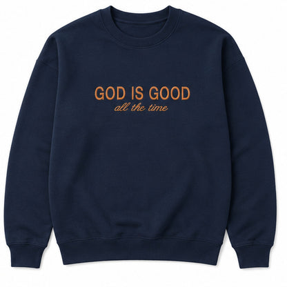 A navy blue crewneck sweatshirt with the text 'GOD IS GOOD all the time' printed on the chest in orange, shown against a plain white background.