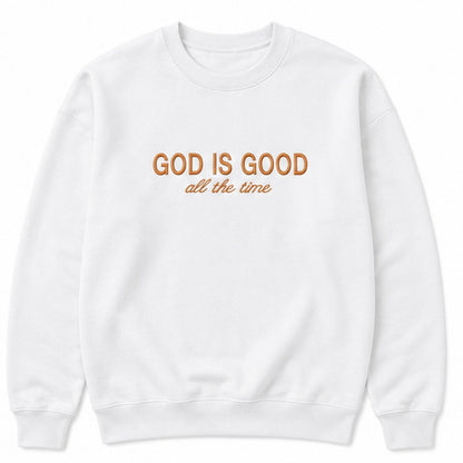 A white crewneck sweatshirt with the text 'GOD IS GOOD all the time' printed on the chest in orange-brown tones, displayed on a clean white background.